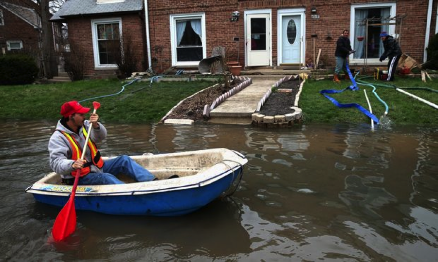 Octavio Castillo paddles a boat down a flooded street to reach the home of his cousin on April 19, 2013 in Des Plaines, Illinois, a suburb of Chicago. (Scott Olson/Getty)